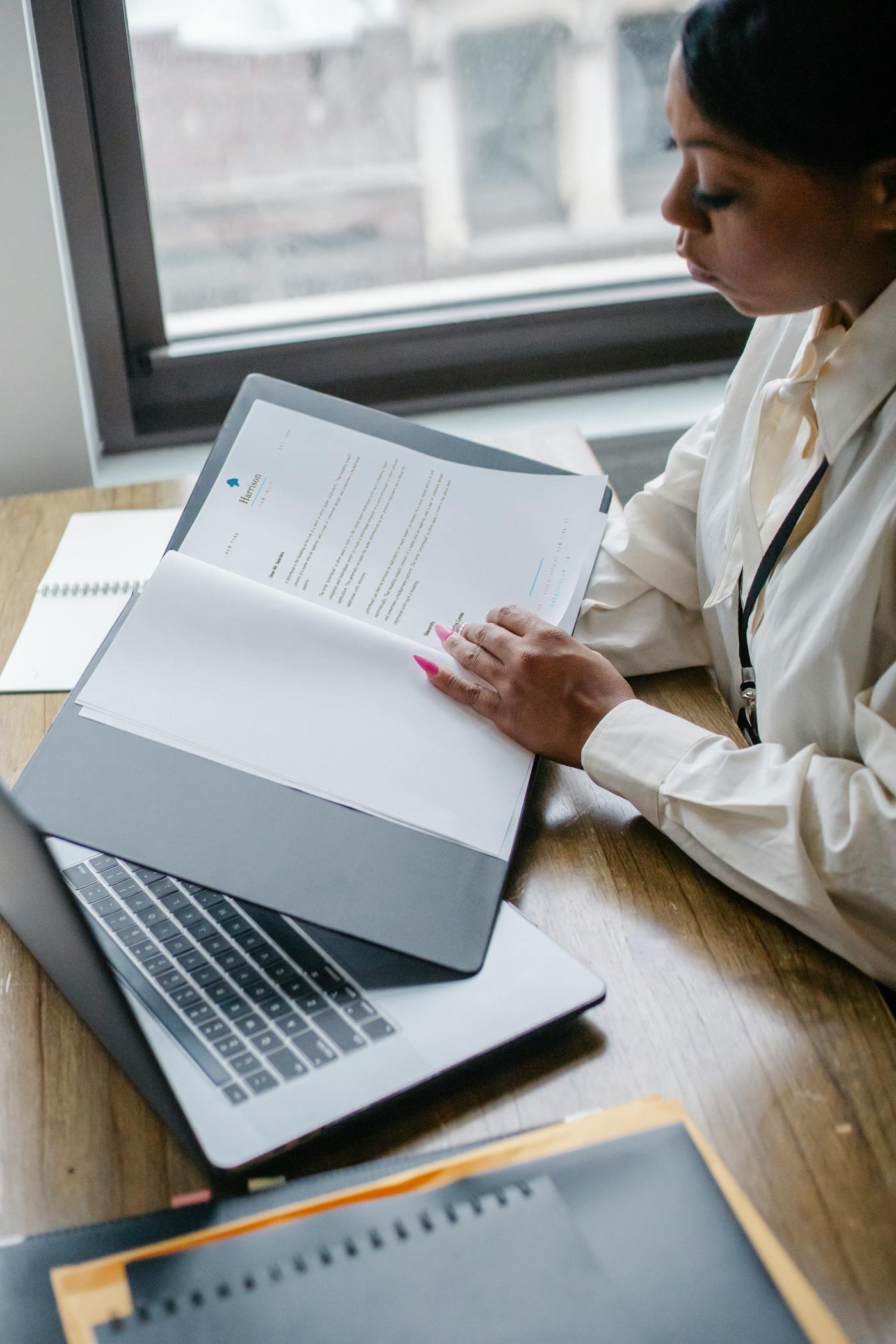 Business owner organizing funding-readiness documents beside a laptop